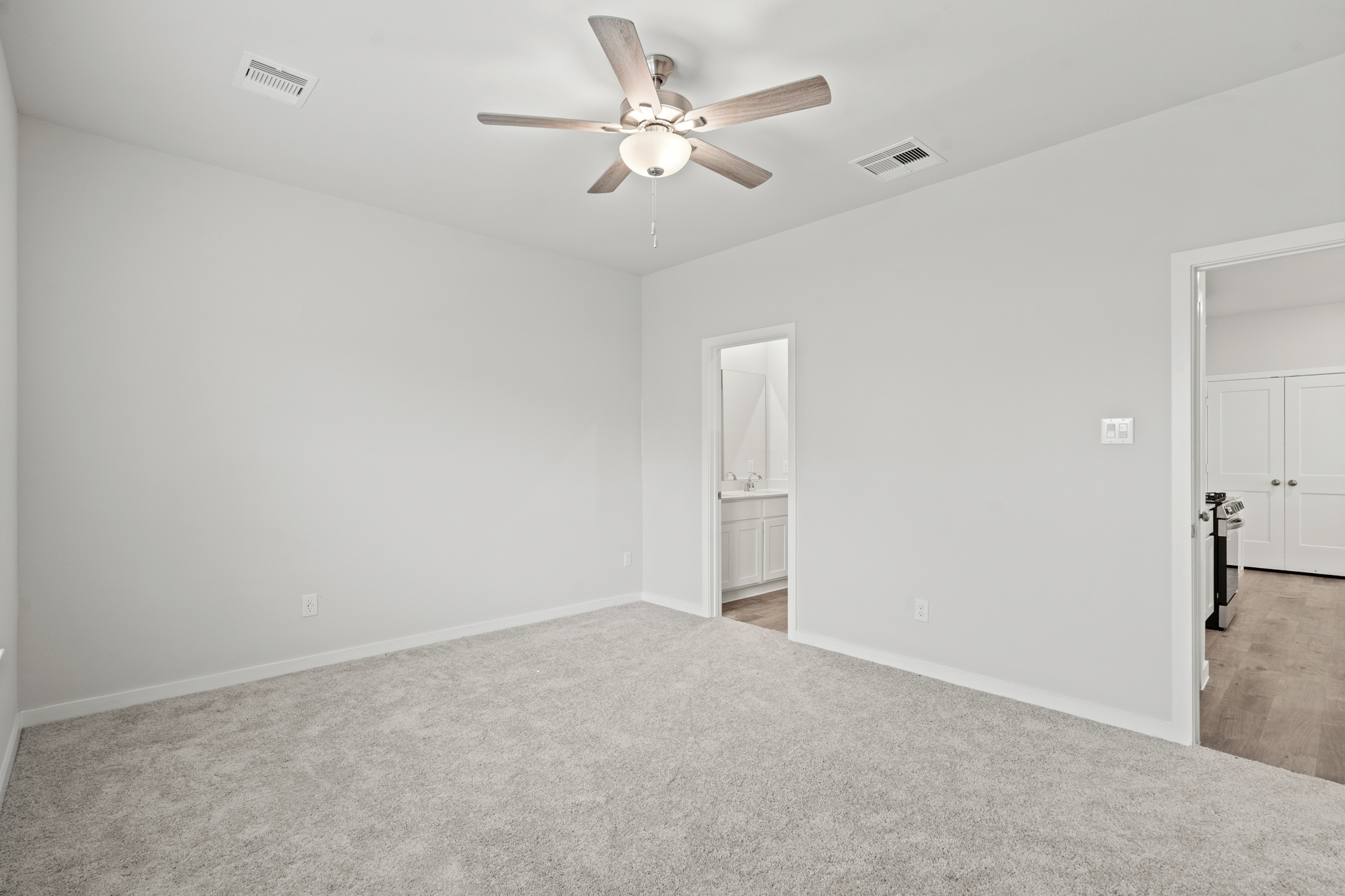 A room with a ceiling fan and a door.