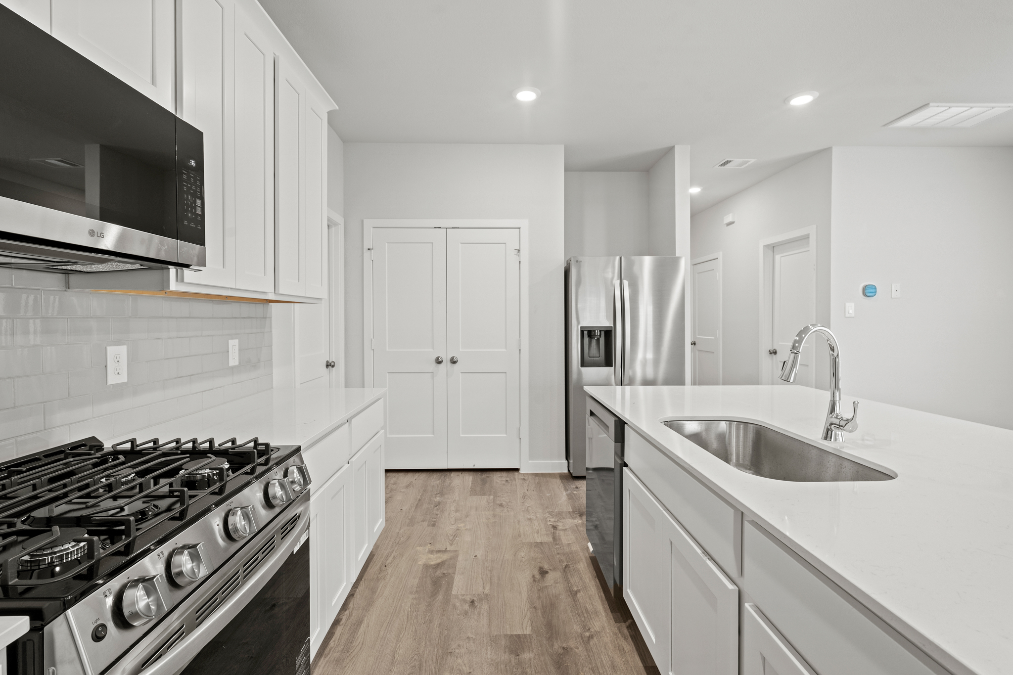 A kitchen with white cabinets.