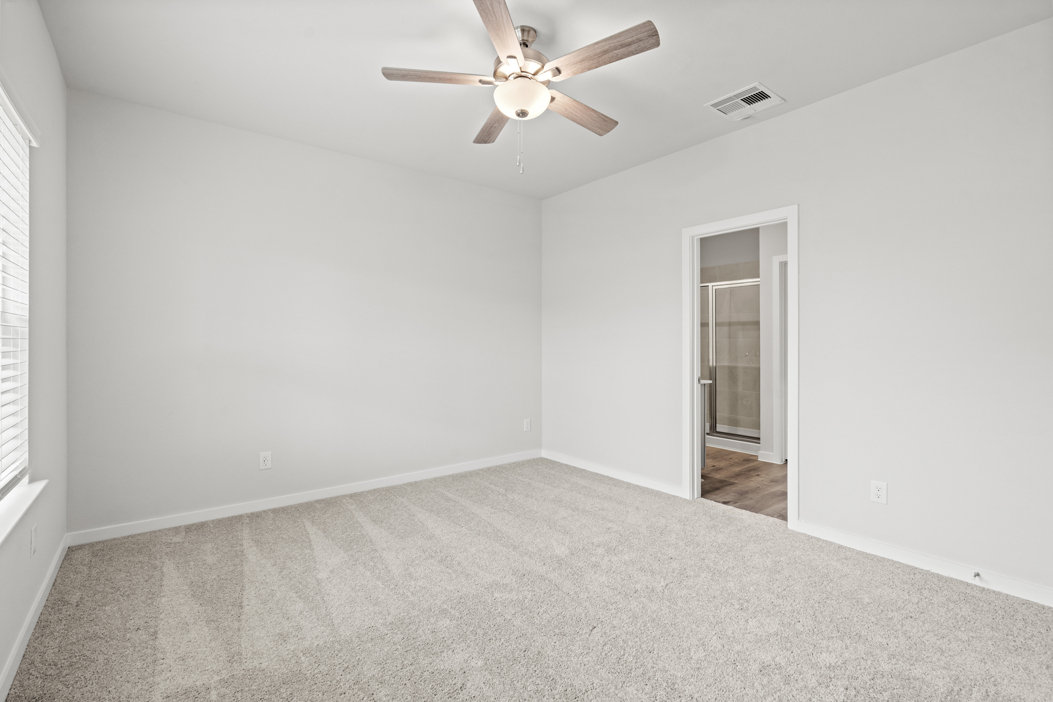 A room with a ceiling fan and a door.