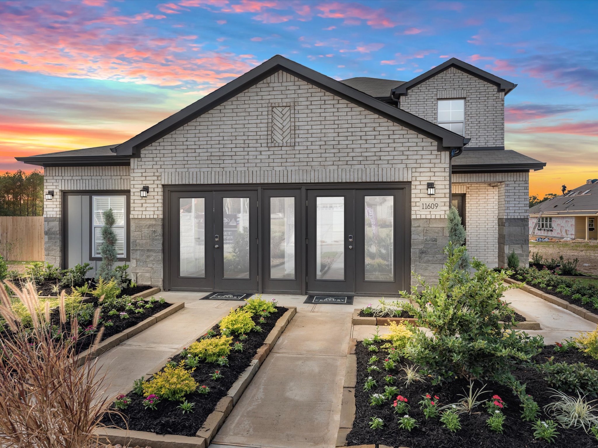 A house with a driveway and a garden in front of it.