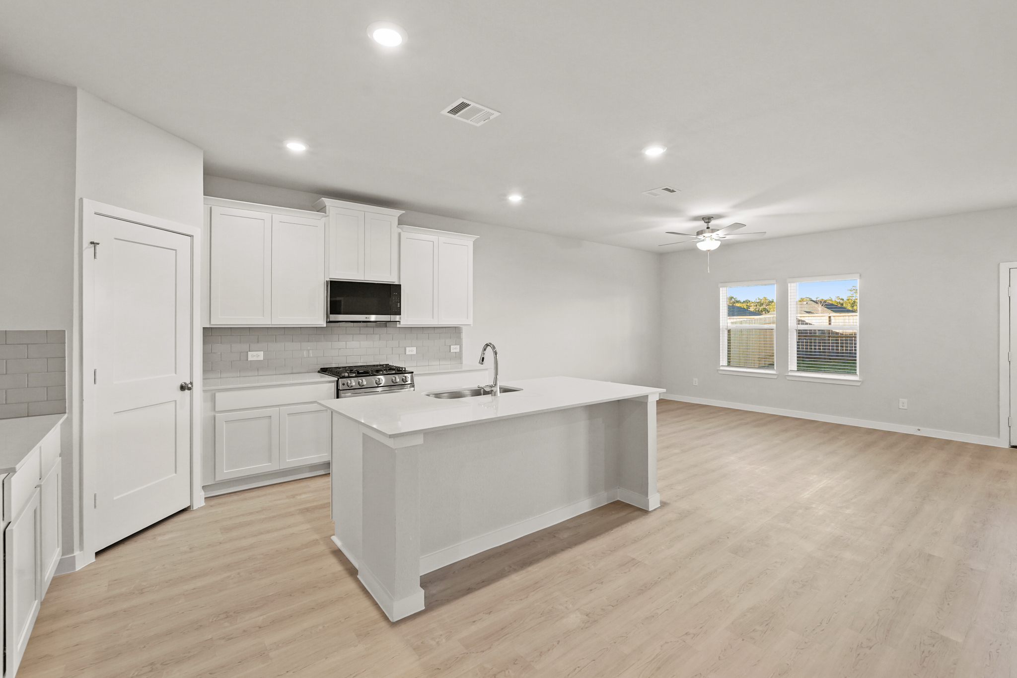 A kitchen with white cabinets.