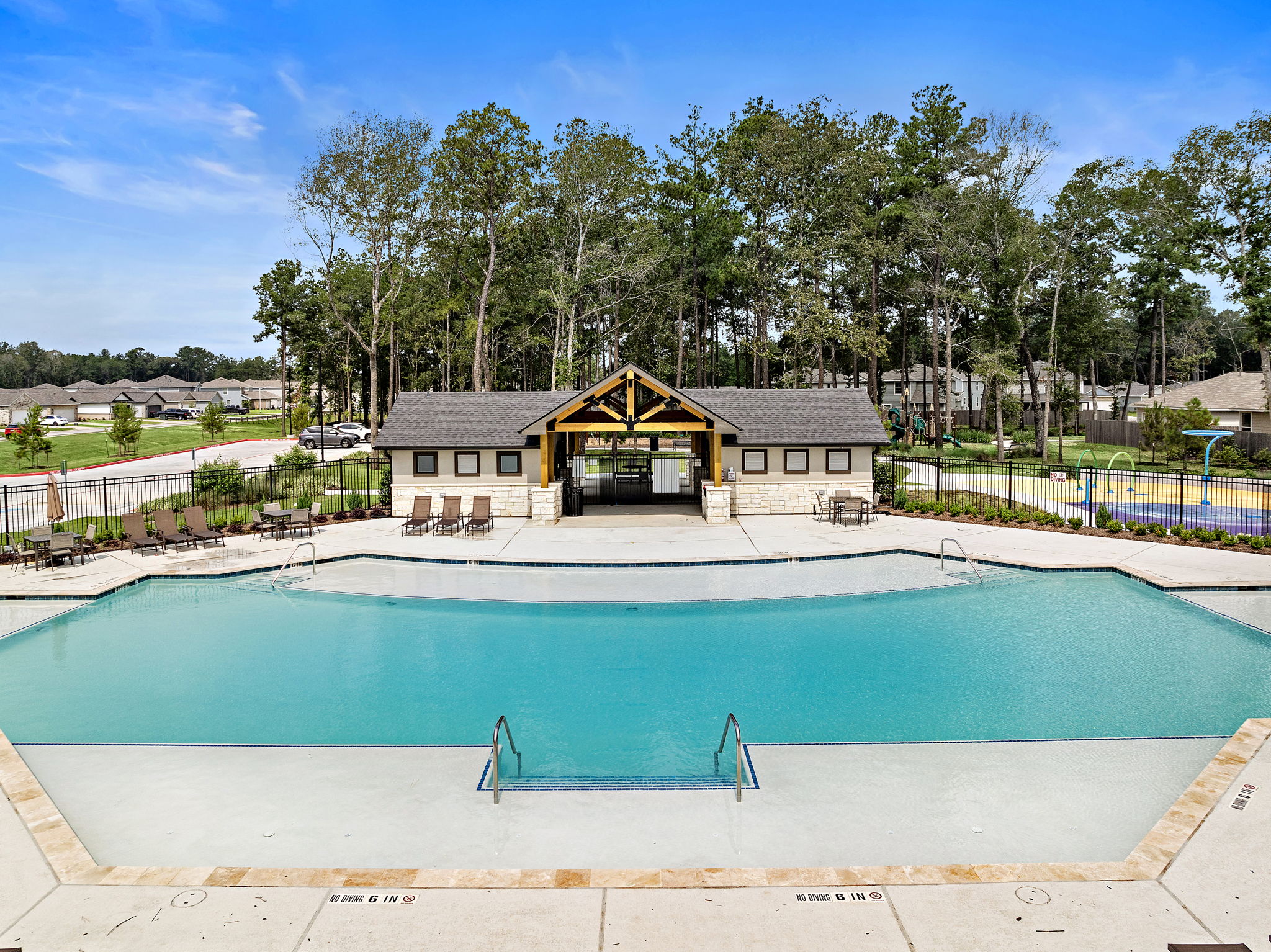 A swimming pool with a house in the background.