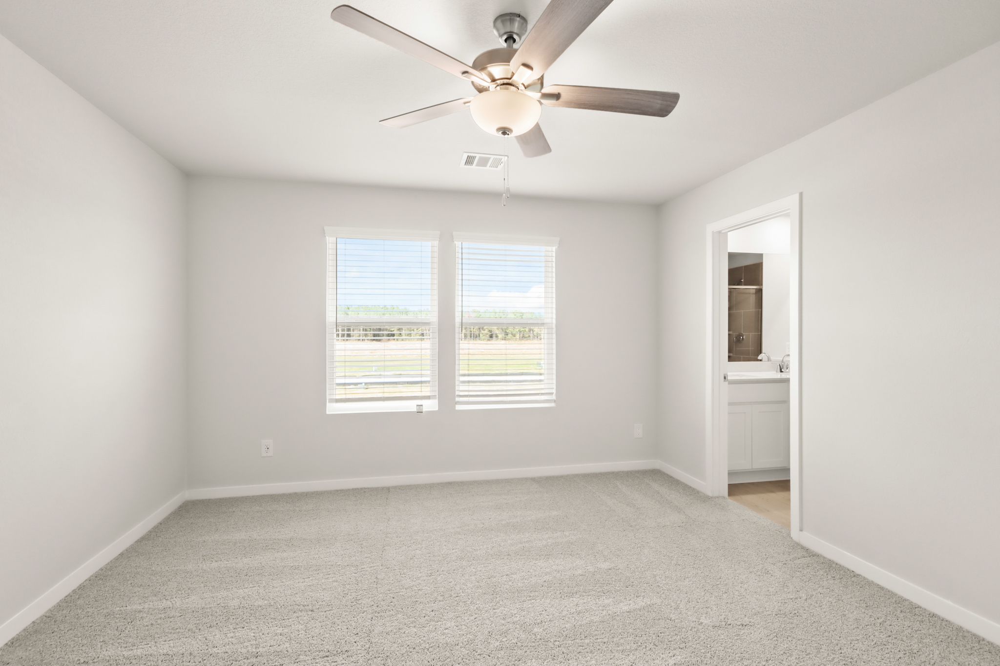 A room with a ceiling fan and a window.