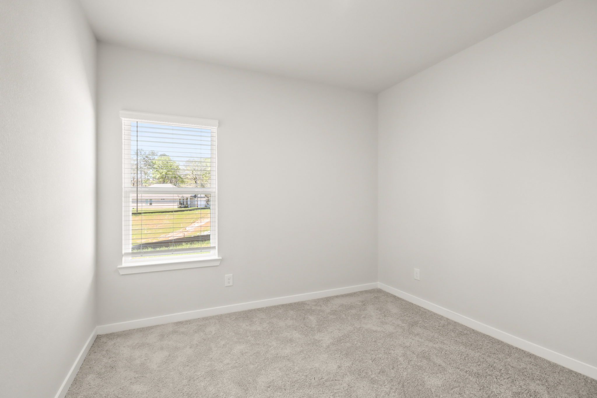 A room with a window and a carpet.