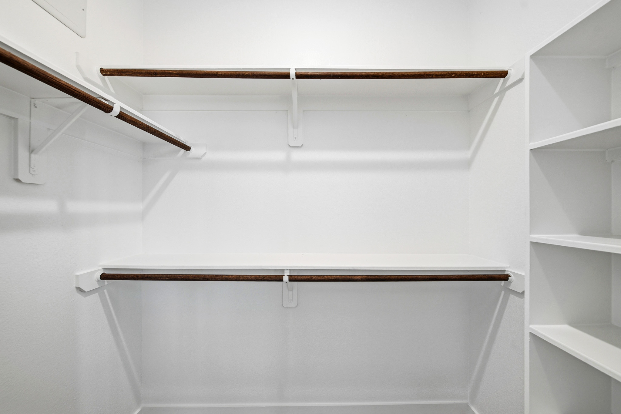 A white shelf with a metal bar.