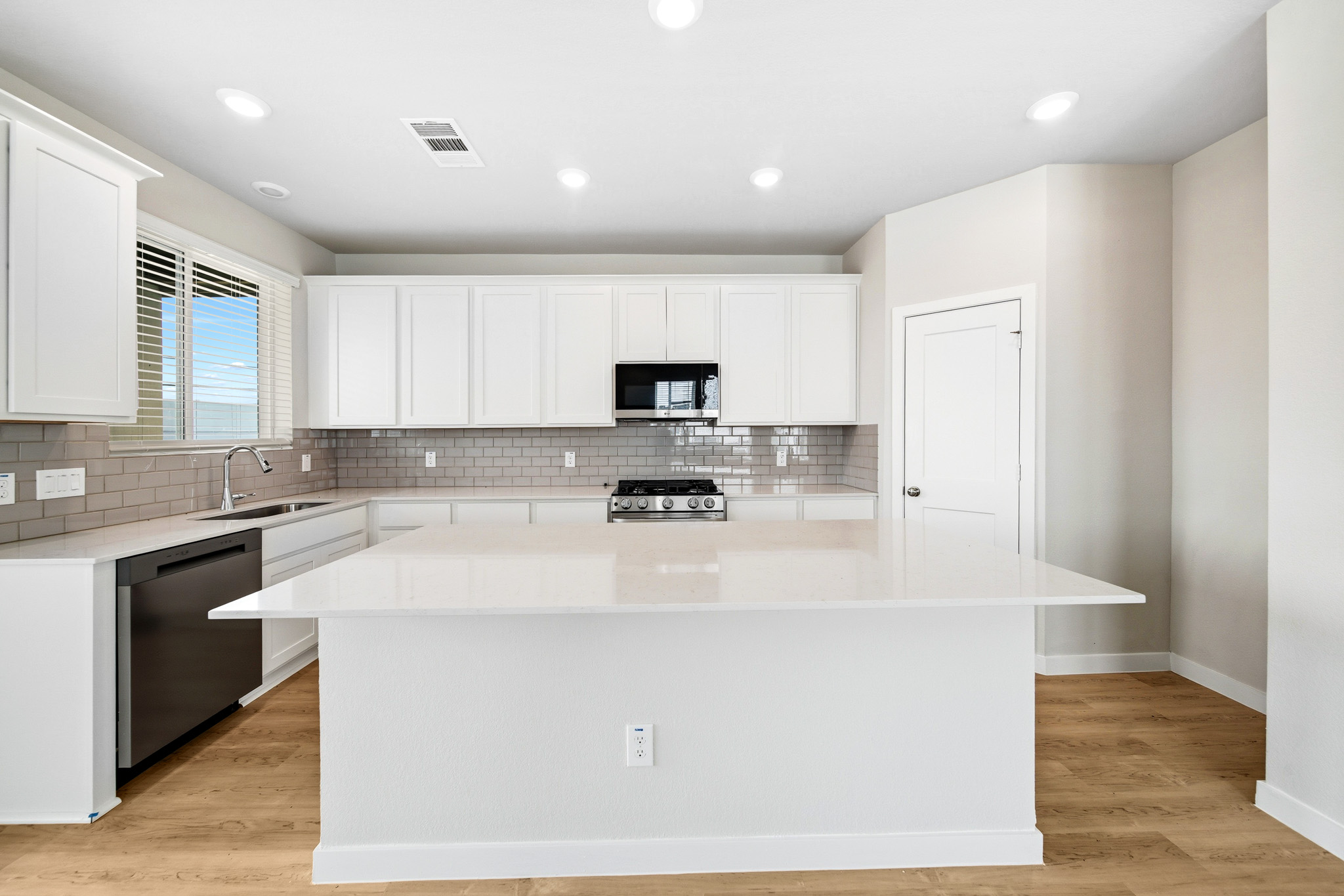 A kitchen with white cabinets.