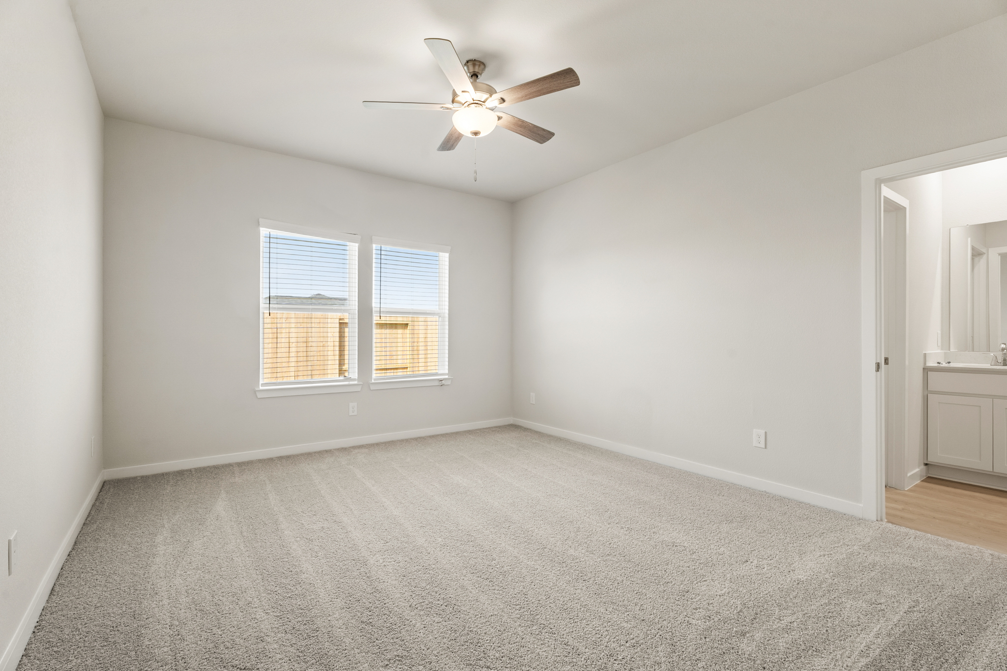 A room with a ceiling fan and a window.
