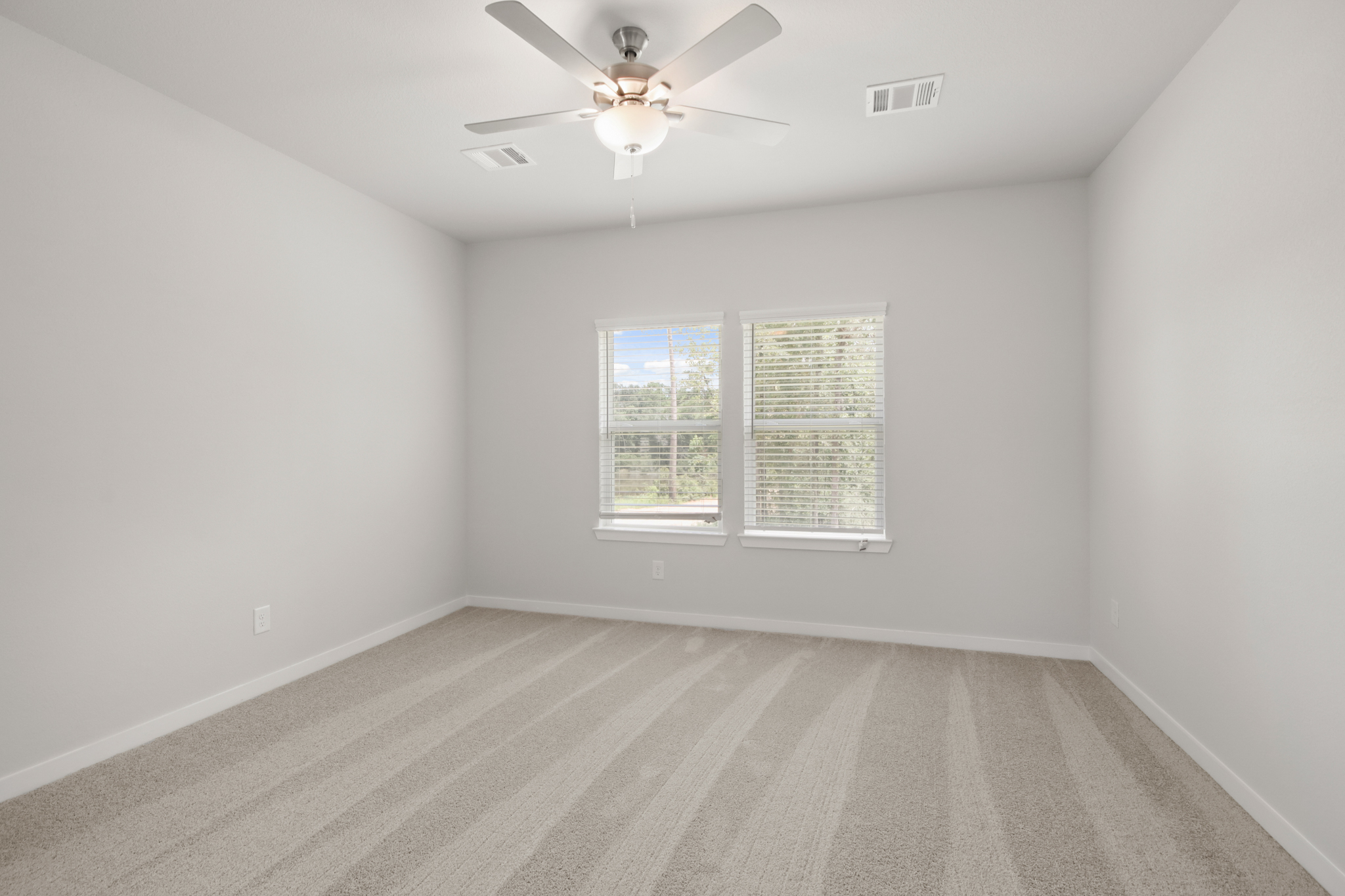 A room with a ceiling fan and a window.