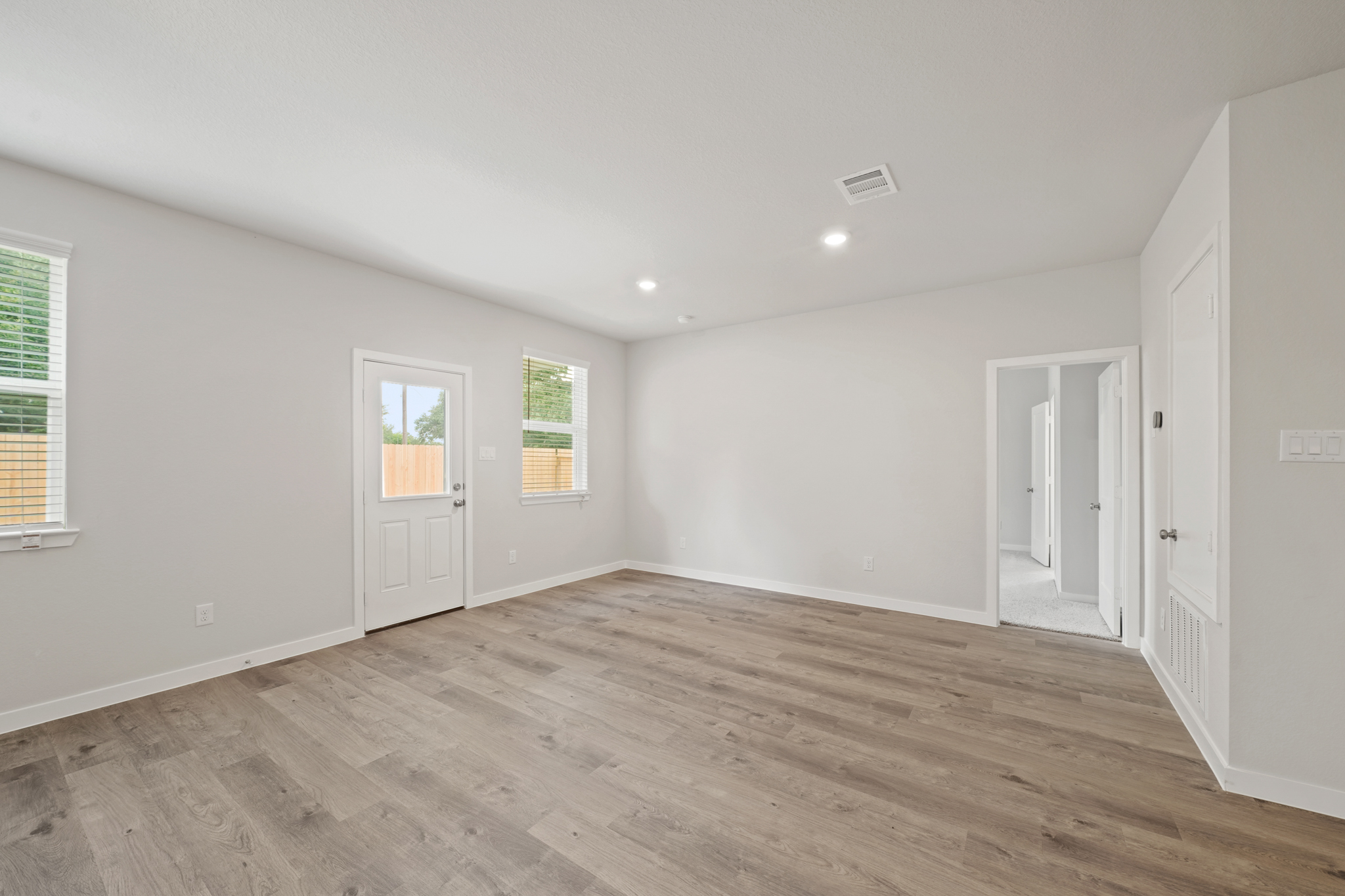 A room with white walls and wood floors.