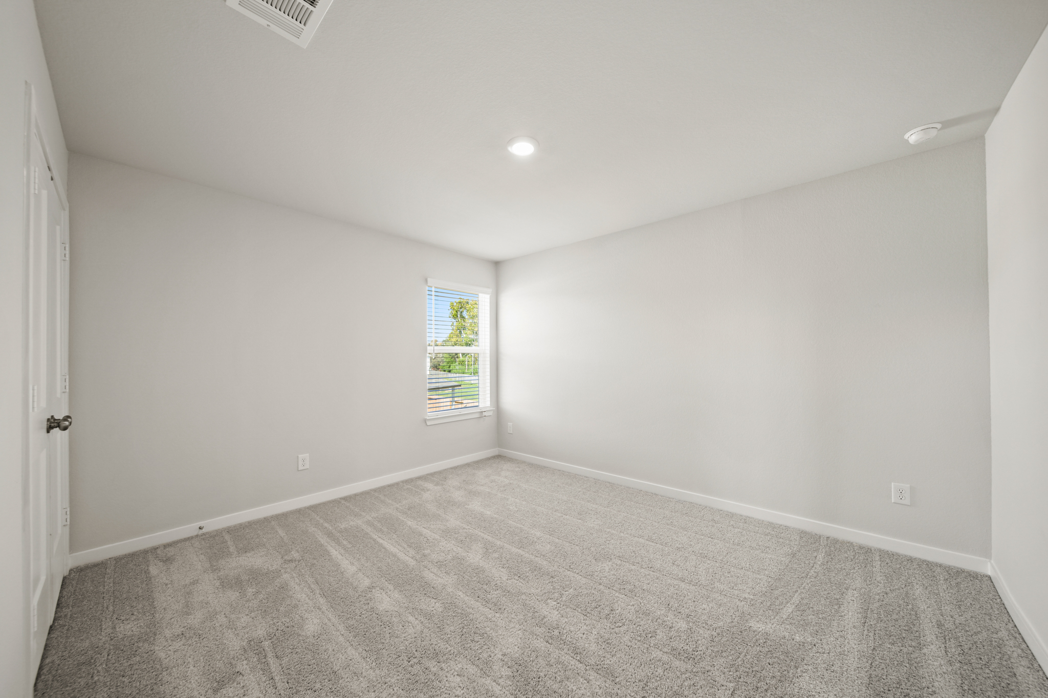 A room with a carpet and a window.