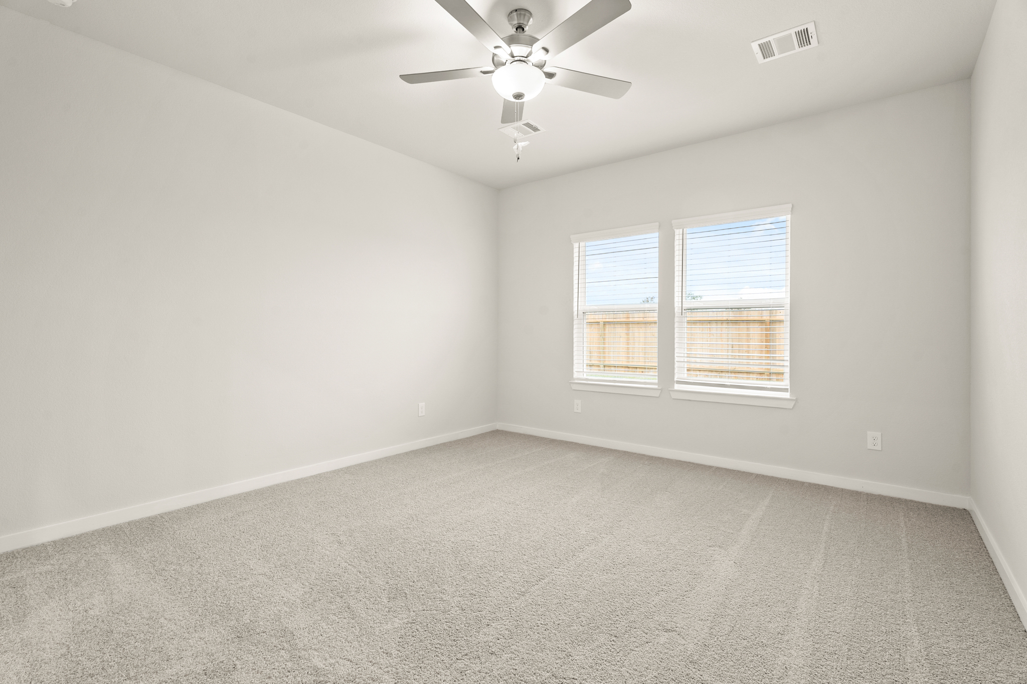 A room with a ceiling fan and a window.