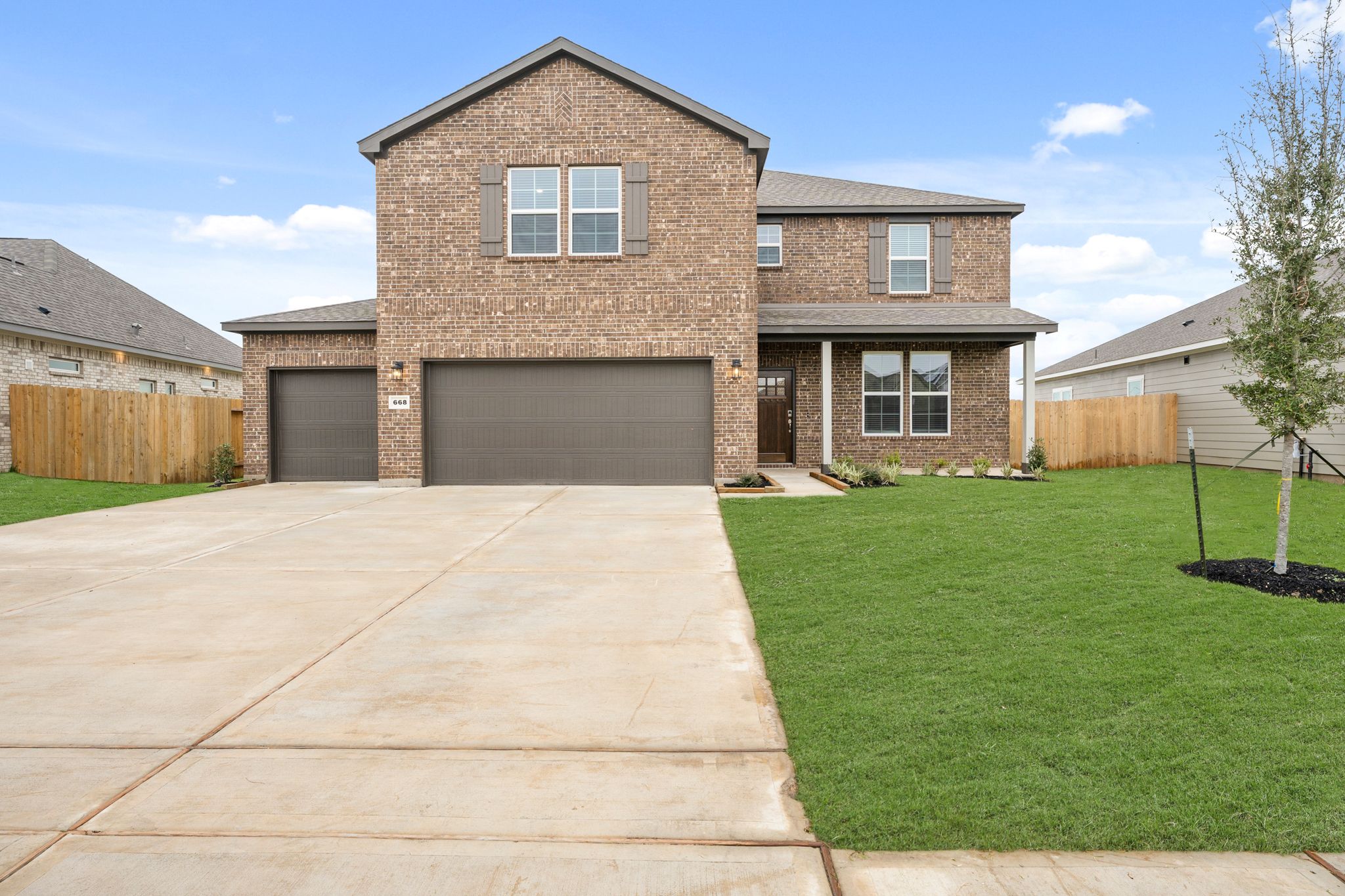 A brick house with a green lawn.