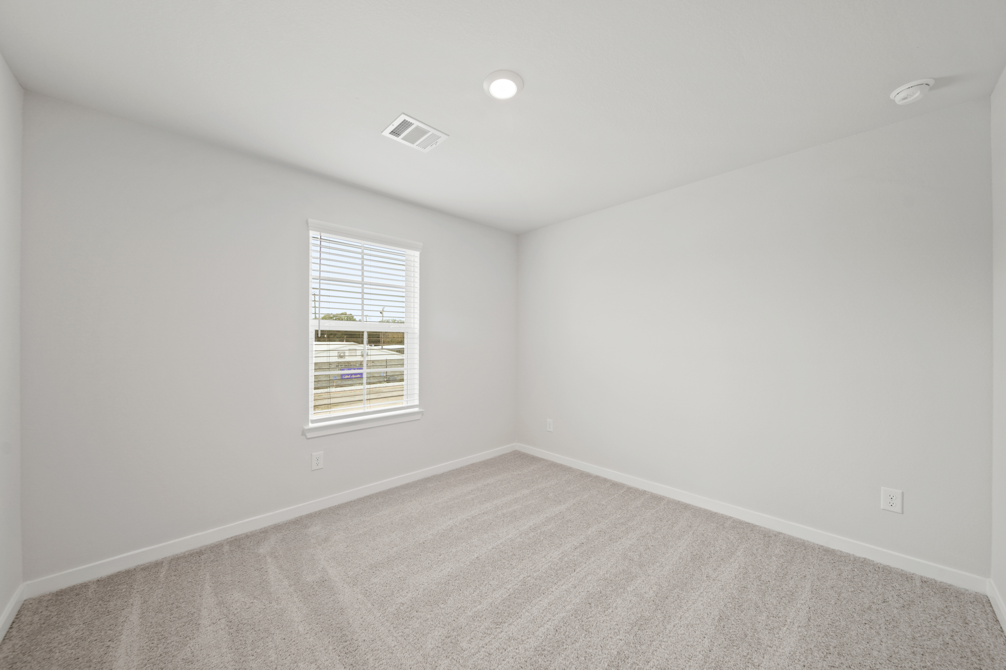 A room with a window and a carpet.