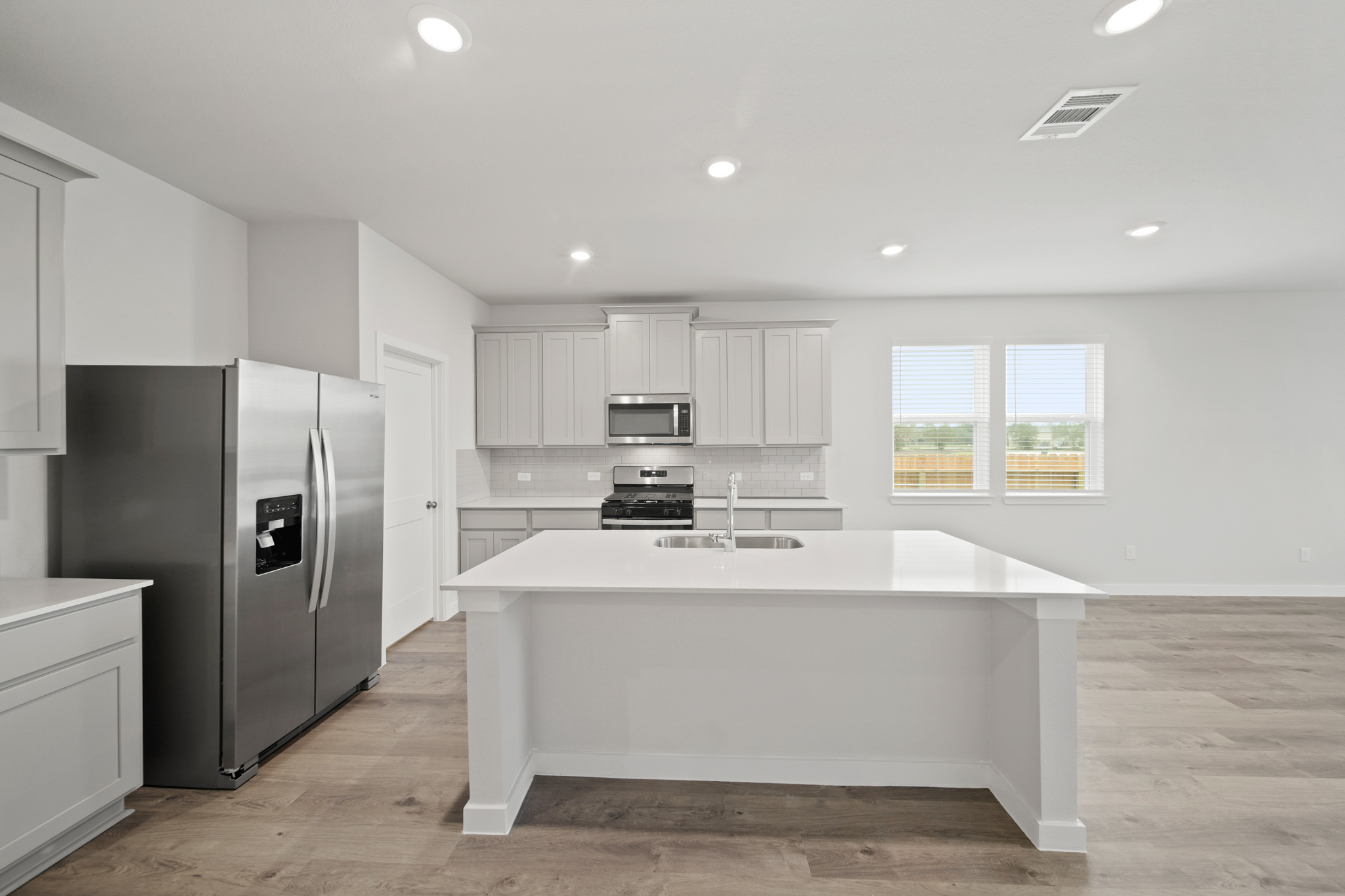 A kitchen with white cabinets.
