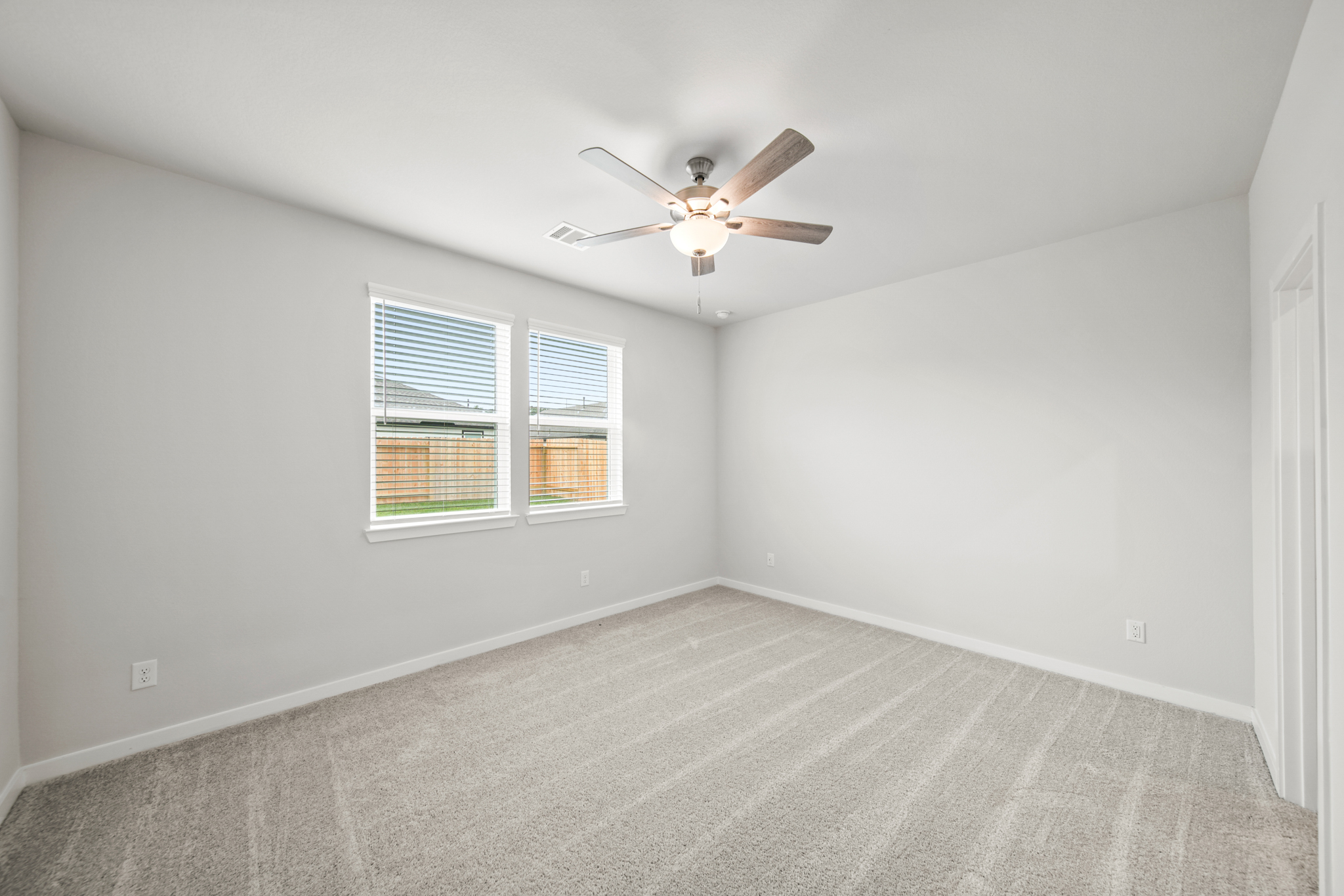 A room with a ceiling fan and a window.