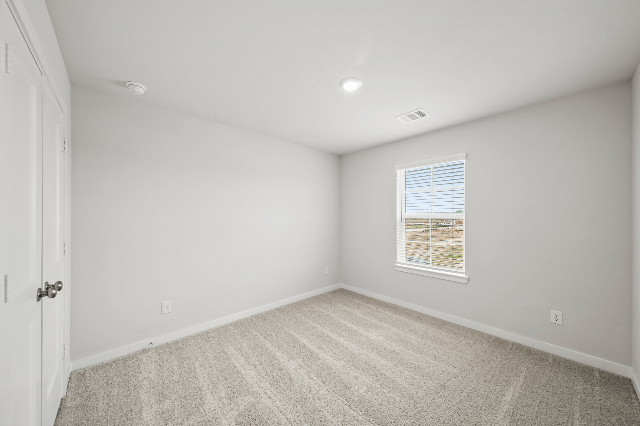A room with a carpet and a window.