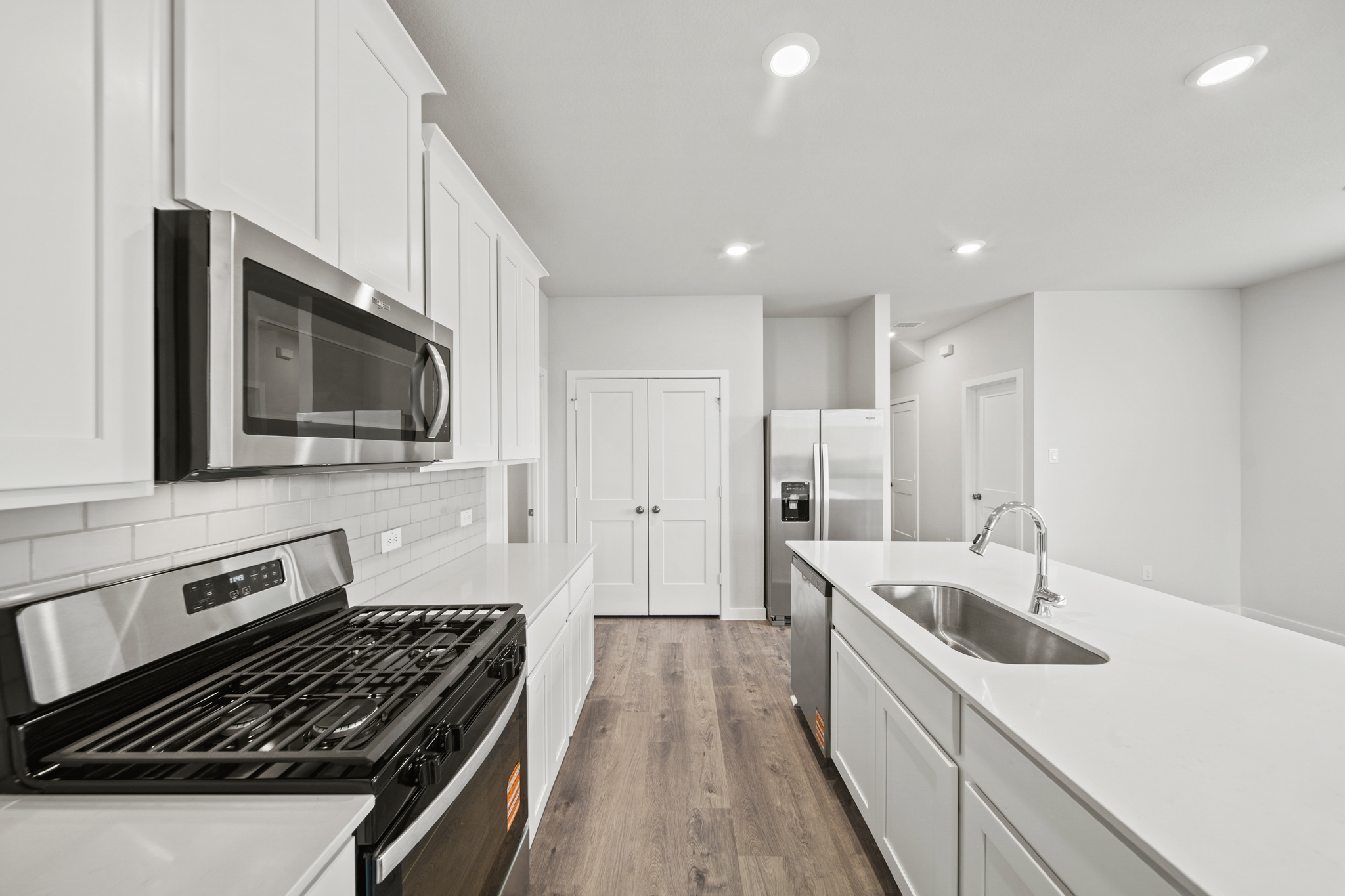 A kitchen with white cabinets.
