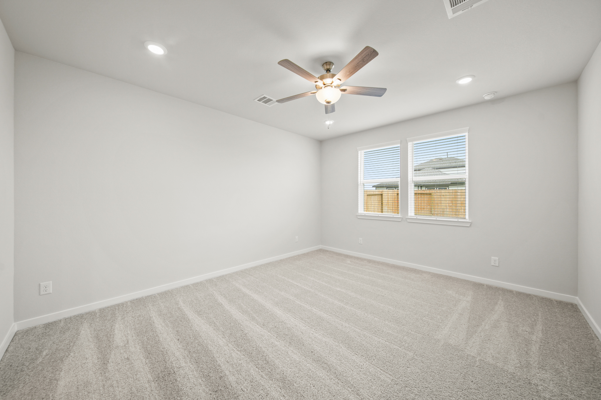 A room with a ceiling fan and a window.