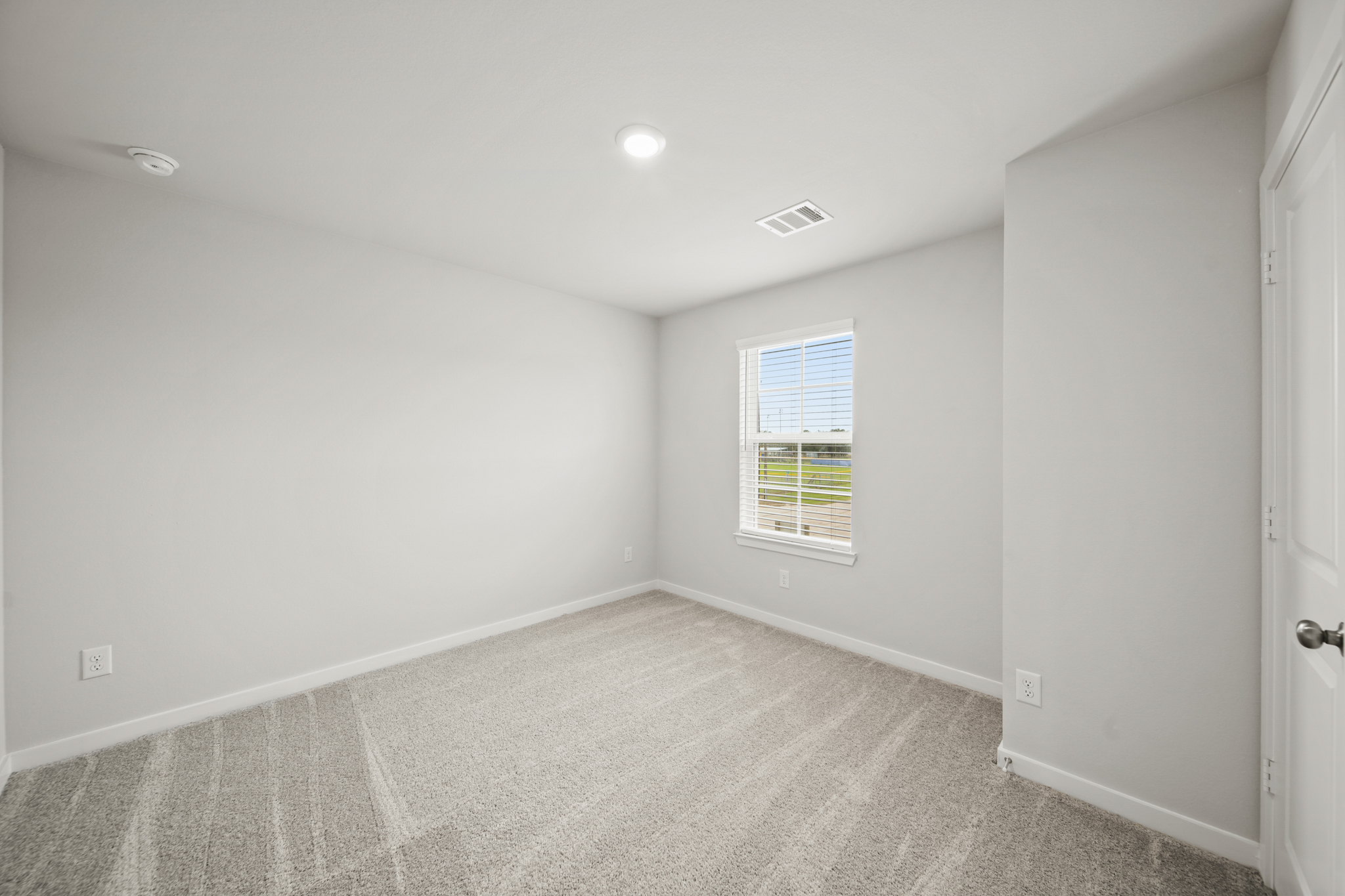 A room with a carpet and a window.