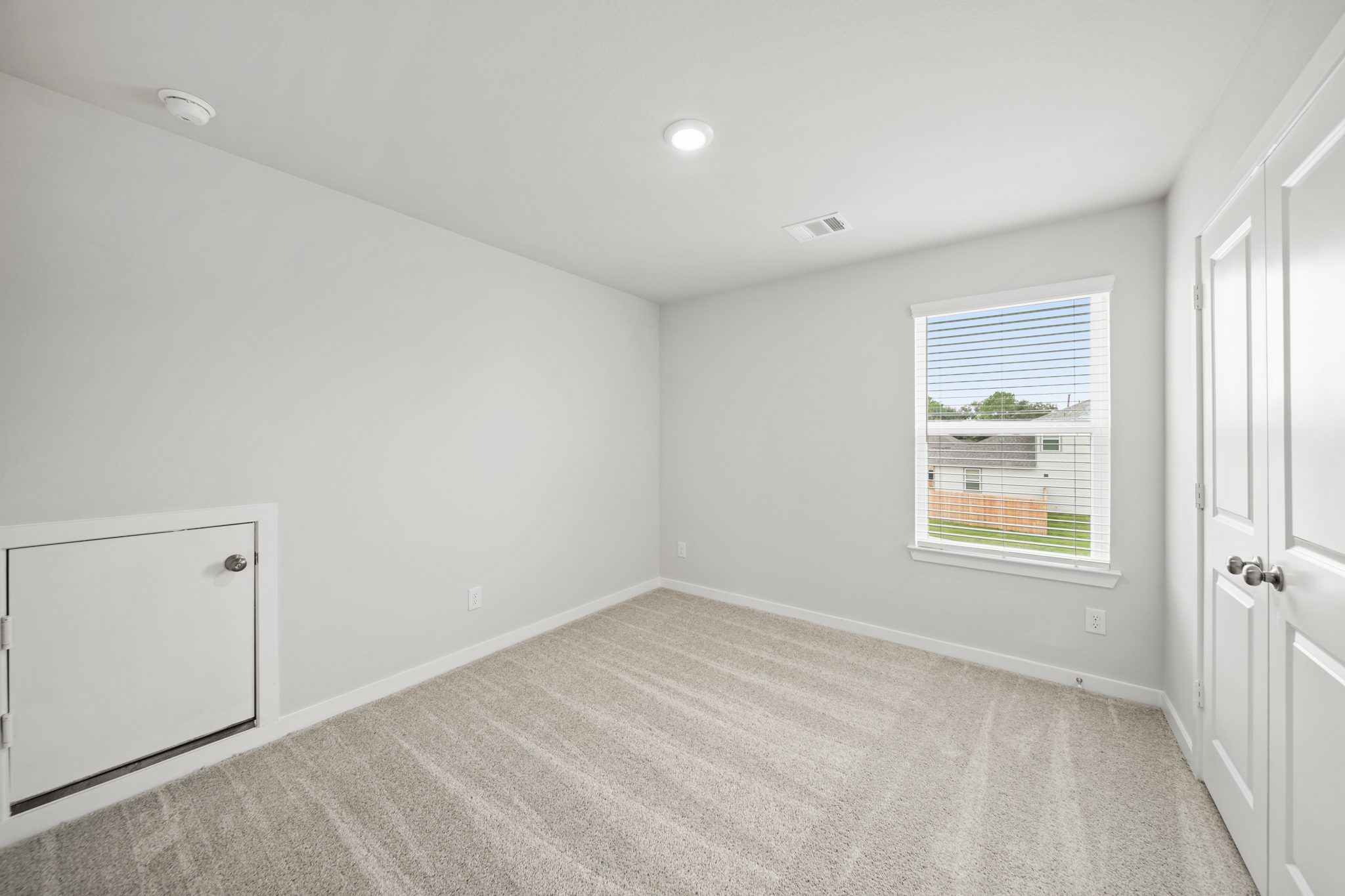 A room with a window and a carpet.