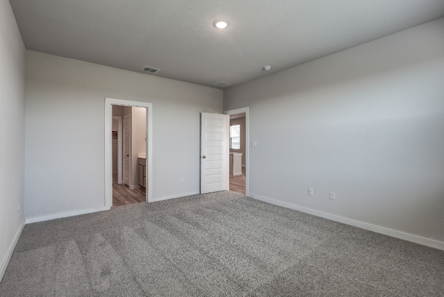 A room with a carpet and a door.