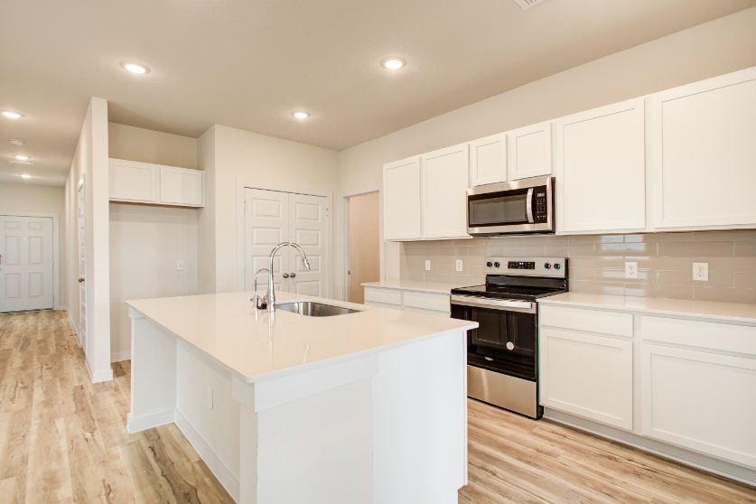 A kitchen with white cabinets.