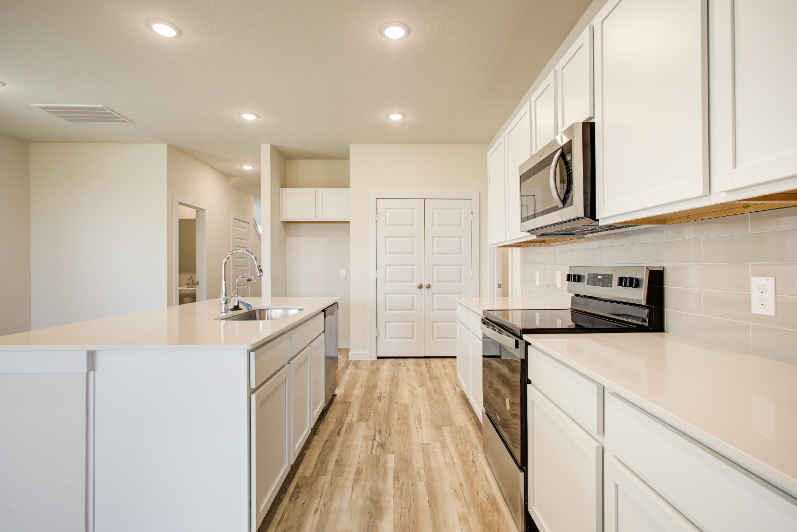A kitchen with white cabinets.
