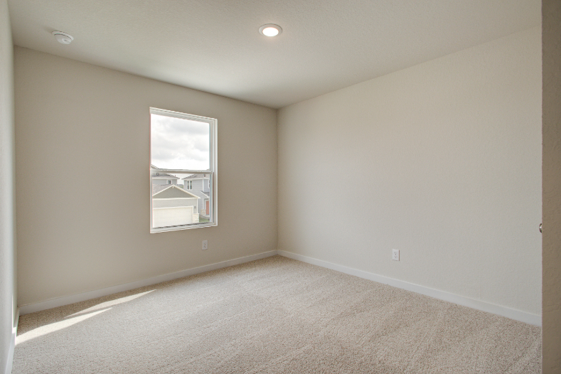 A room with a window and carpet.