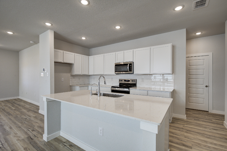 A kitchen with white cabinets.