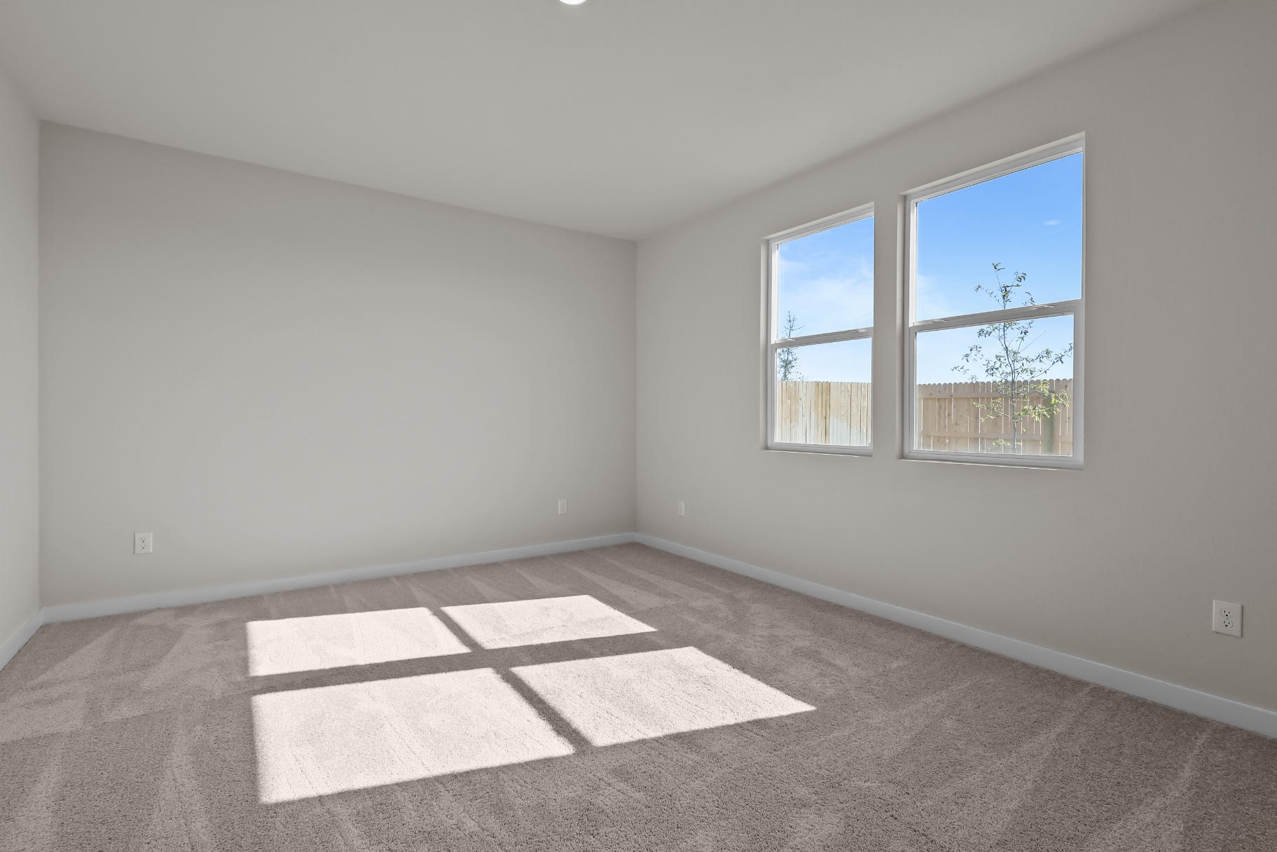 A room with a rug and a window.