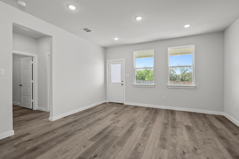 A room with a wood floor and windows.