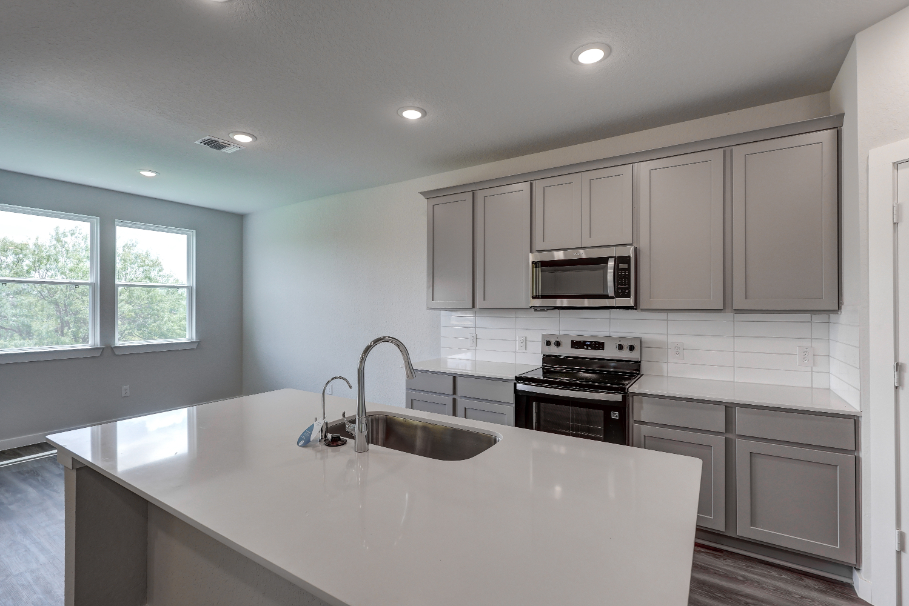 A kitchen with white cabinets.