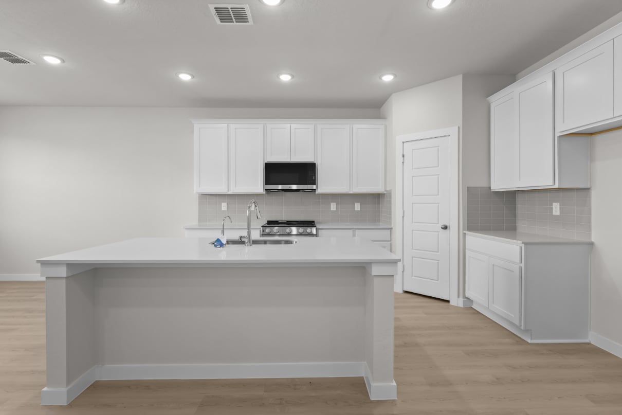 A kitchen with white cabinets.