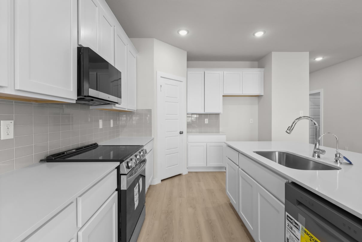 A kitchen with white cabinets.