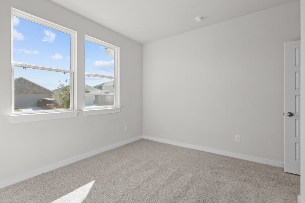 A room with a window and a carpet.