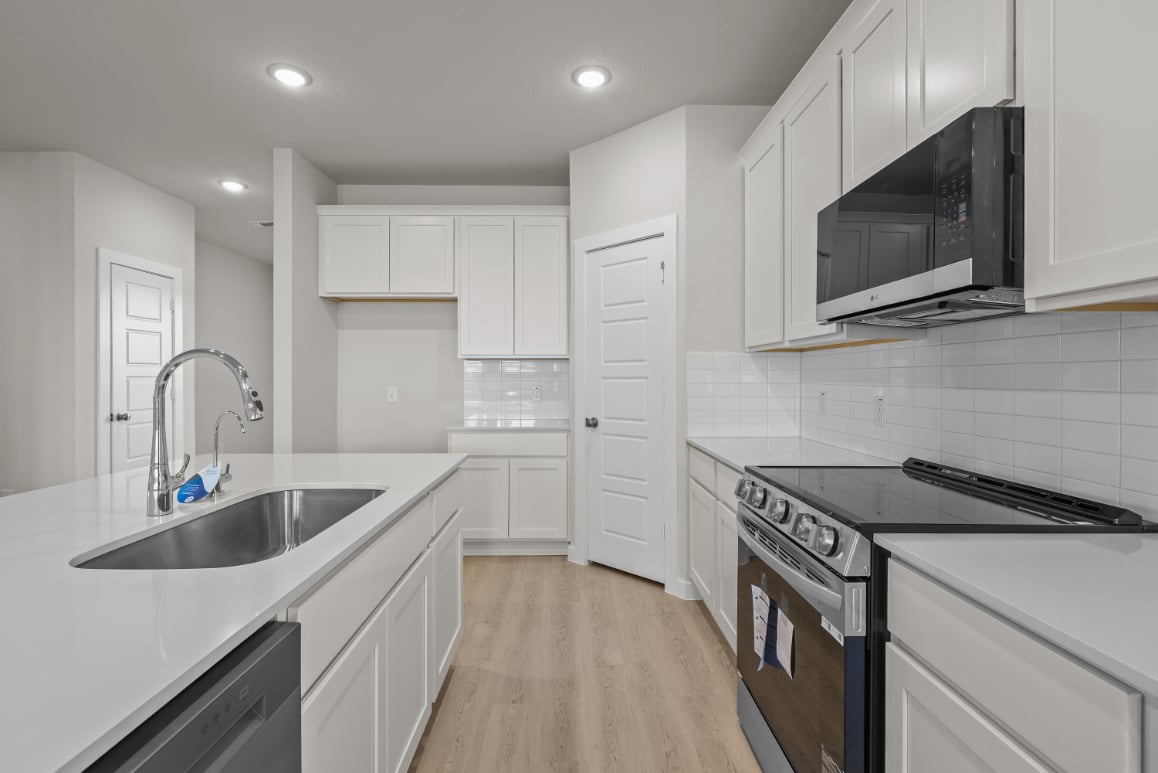 A kitchen with white cabinets.