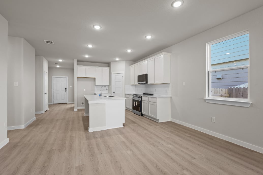 A kitchen with white cabinets.