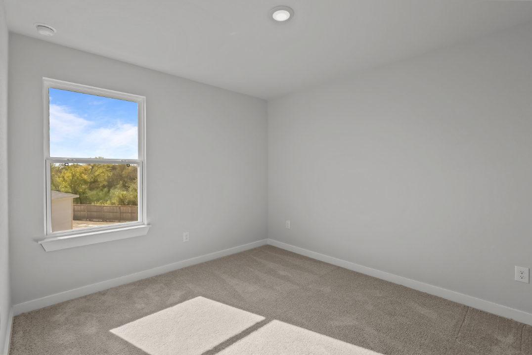 A room with a window and a rug in it.