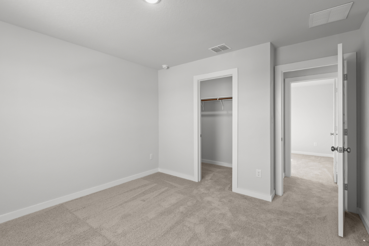 A room with a door and a mirror.
