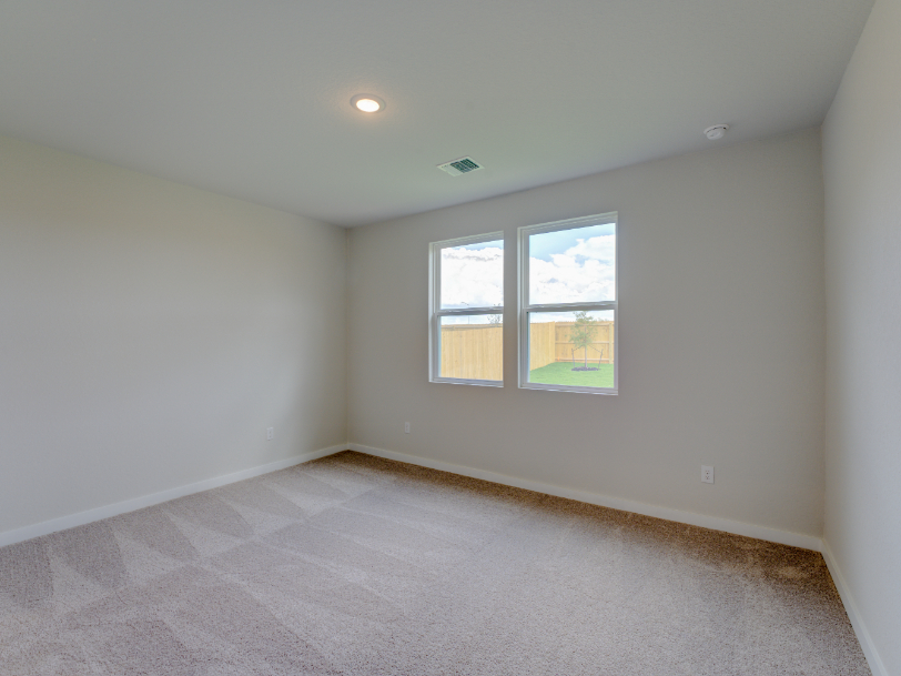 A room with a window and a carpet.