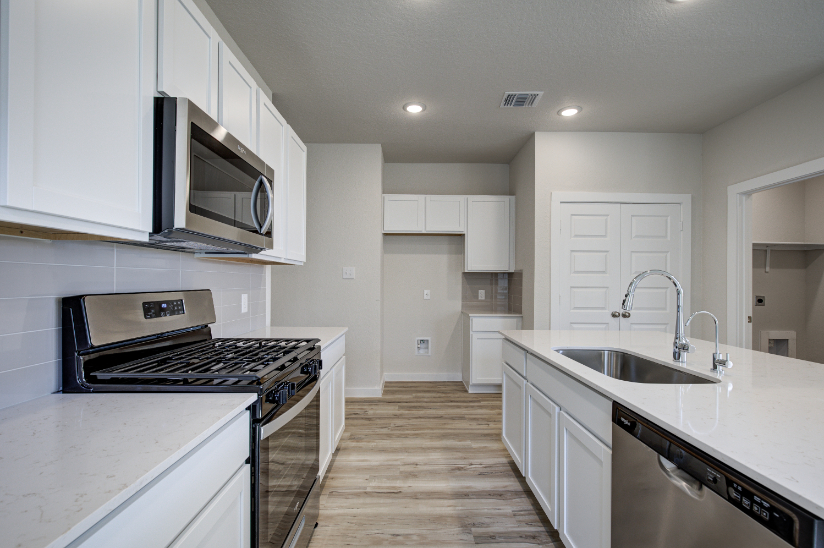 A kitchen with white cabinets.