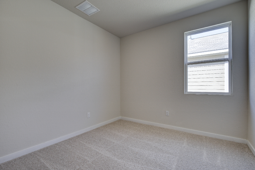 A room with a window and a carpet.