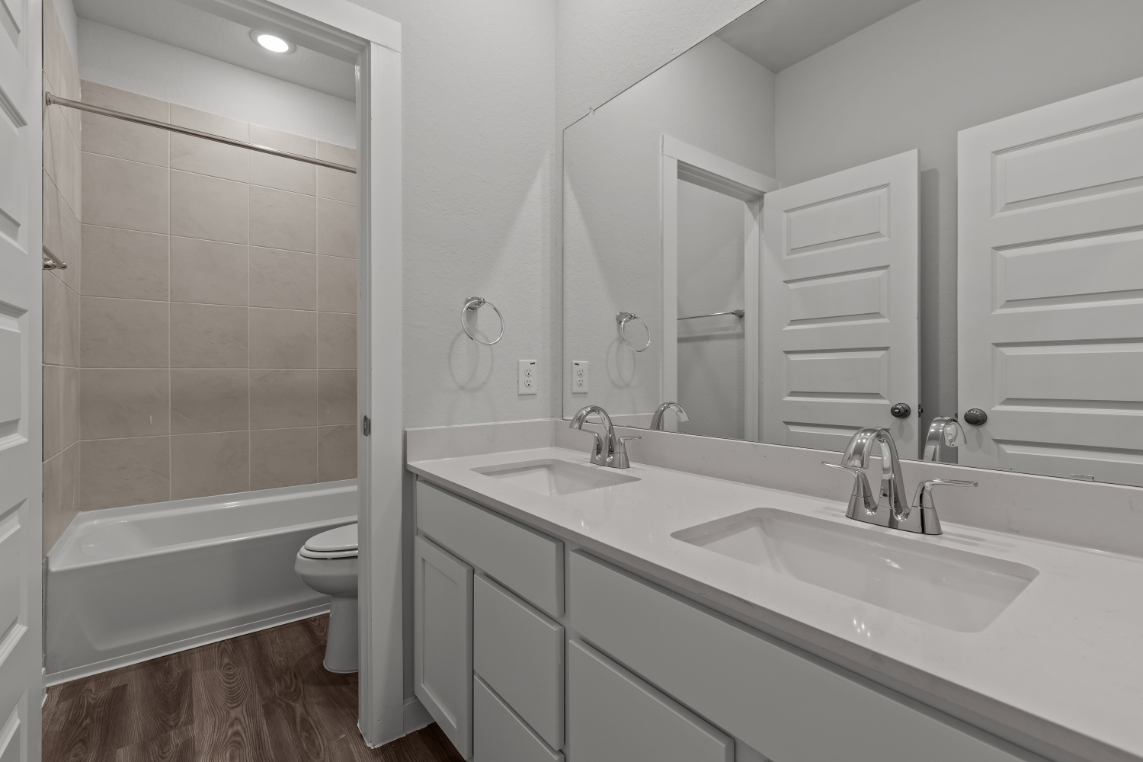 A bathroom with a tub sink and toilet.