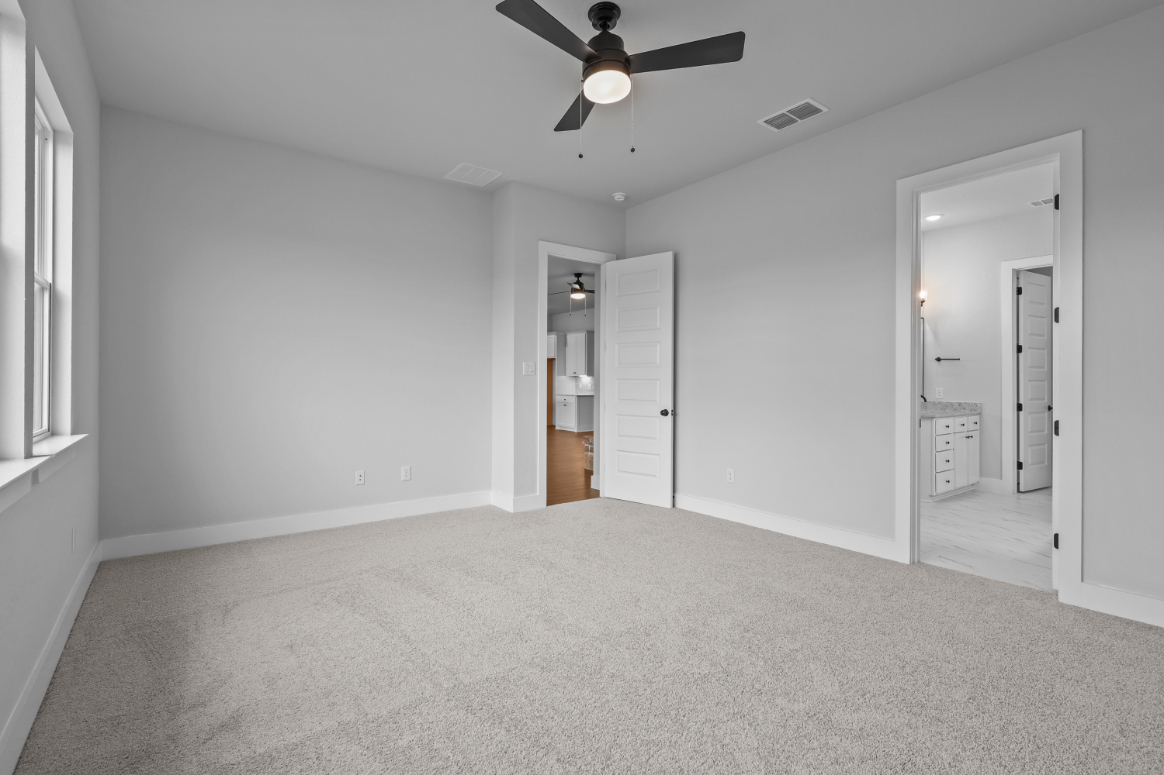 A room with a ceiling fan and a door.