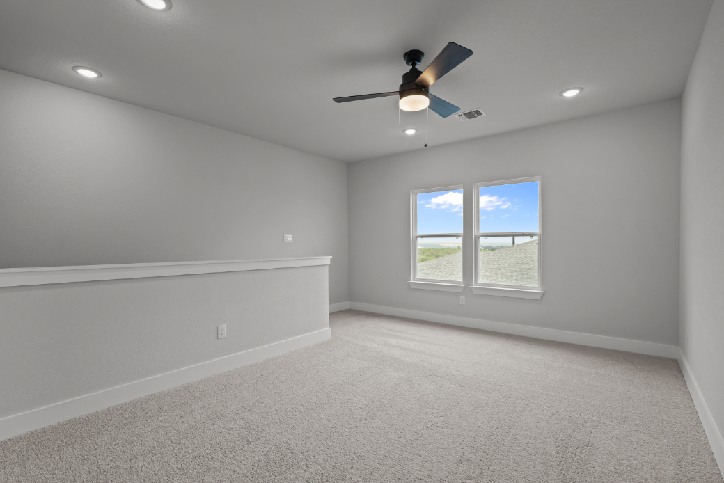 A room with a ceiling fan and a window.
