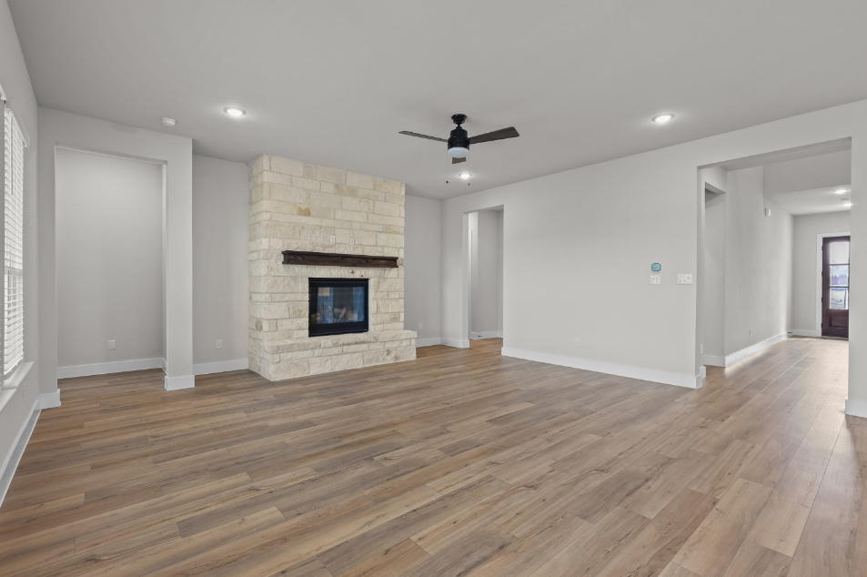 A room with a fireplace and a wood floor.