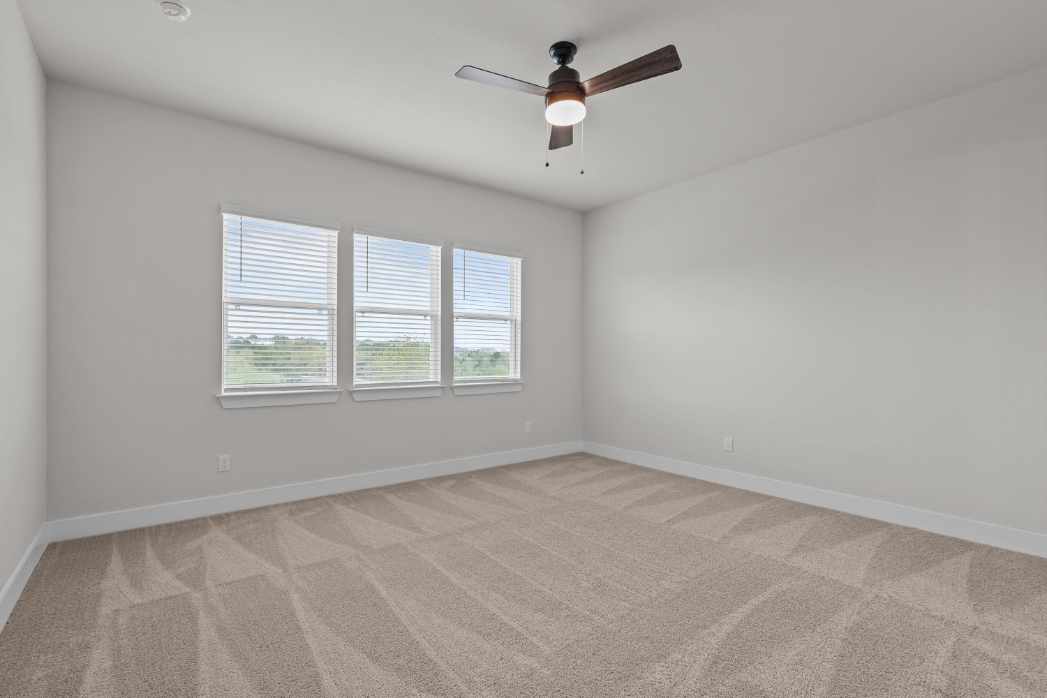 A room with a ceiling fan and a window.