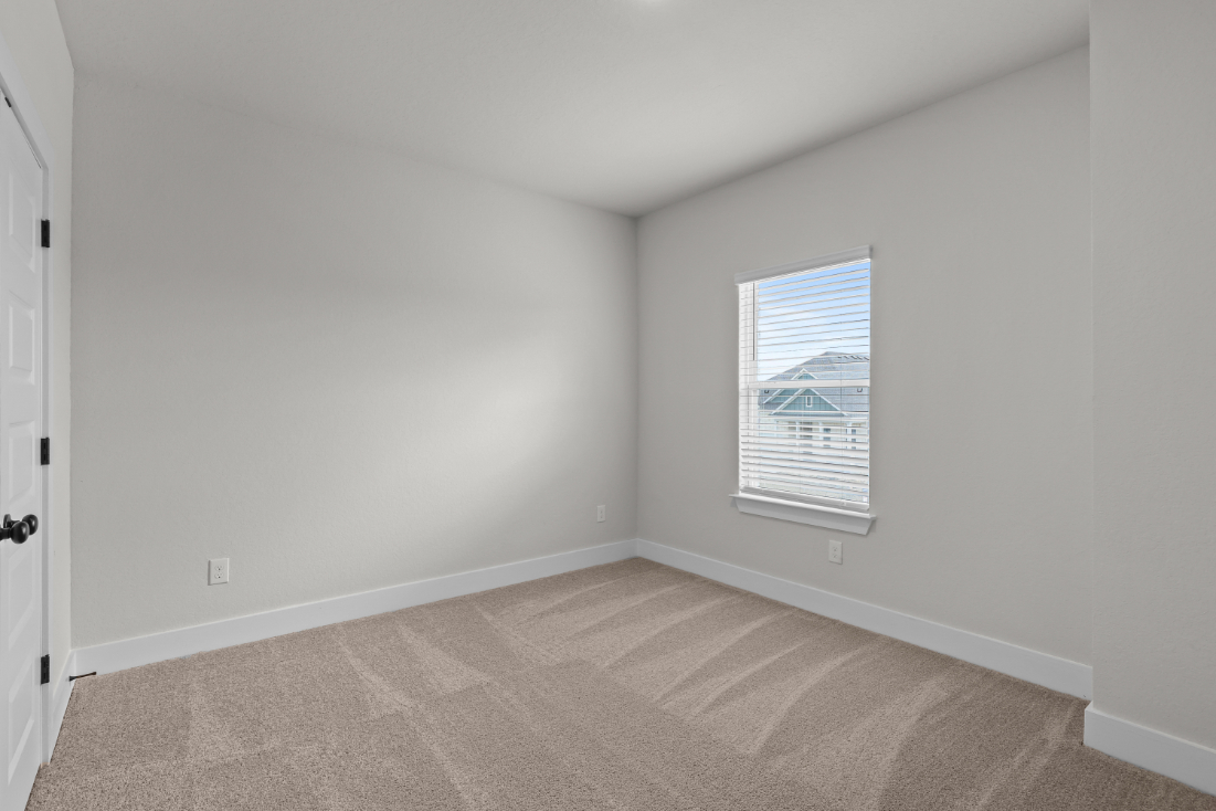 A room with a carpet and a window.
