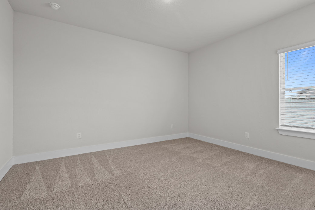 A room with a carpet and a window.