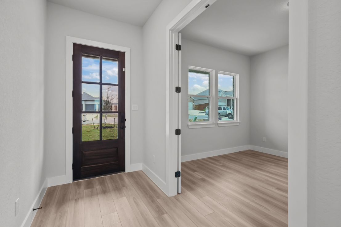 A room with a wood floor and a door with a window.